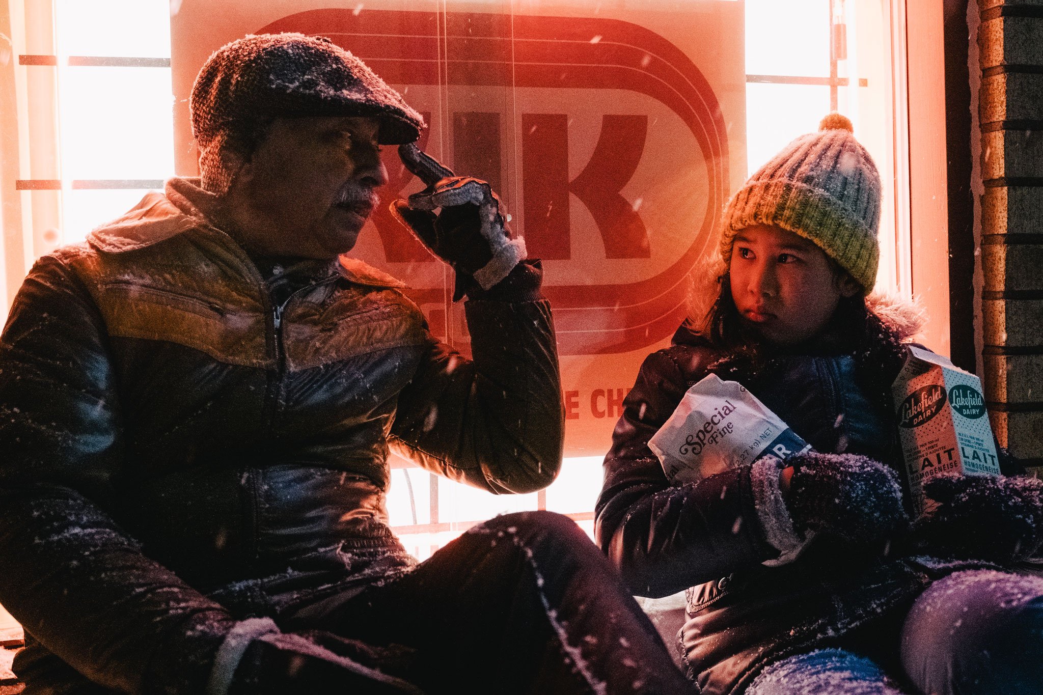 homme et jeune fille discutent dehors de nuit sous la neige