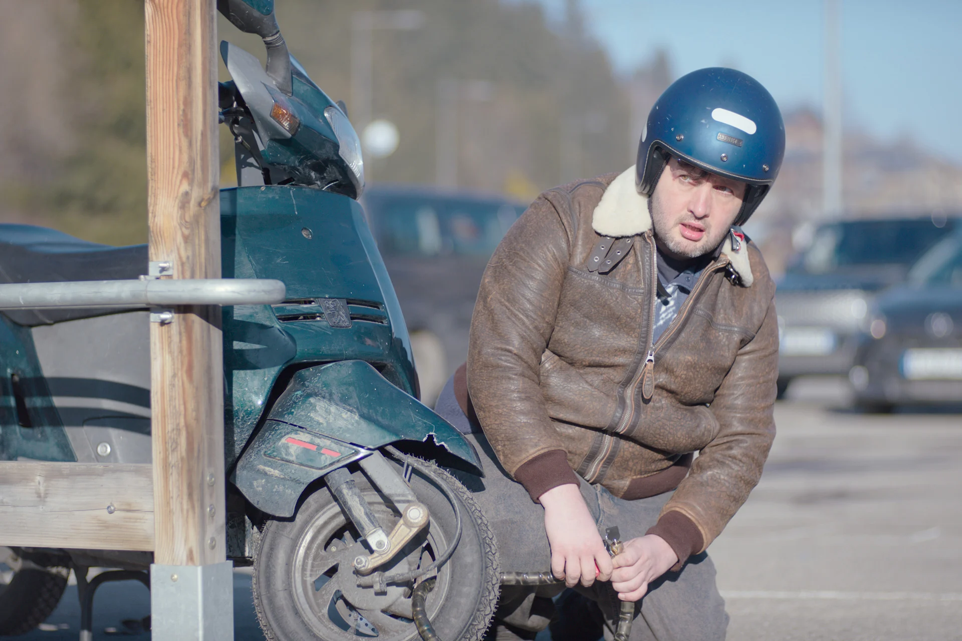 homme avec un casque à côté d'un scooter