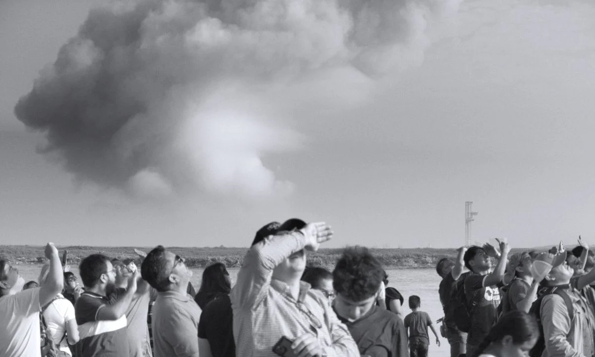 image en noir et blanc de gens qui regardent une fusée s'envoler